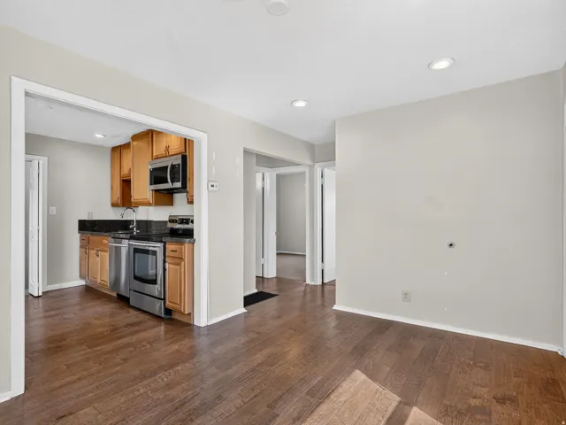 Open-concept living space featuring wood-finish flooring, recessed lighting, and light neutral wall colors