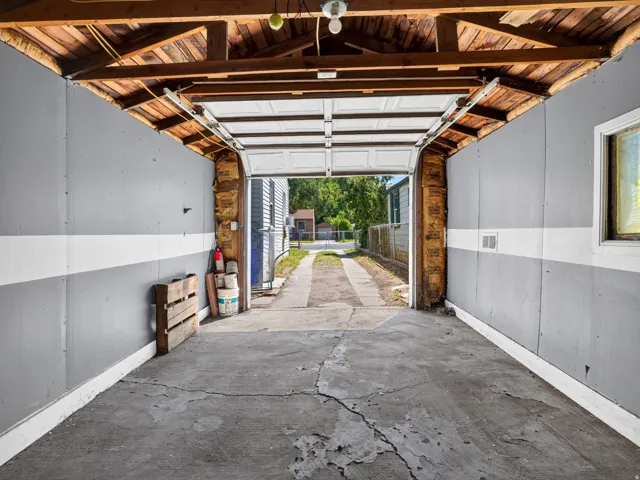 Attached garage with an exposed wood beam ceiling and concrete flooring