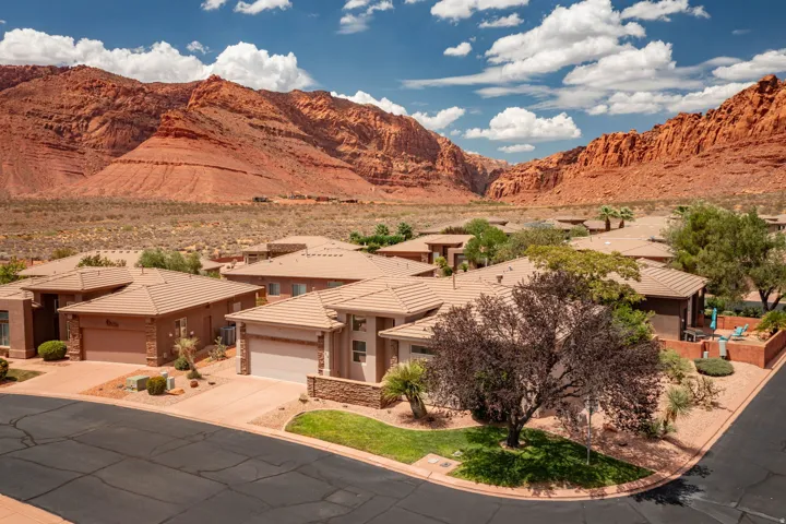 Expansive residential area featuring homes with attached garages, light-colored stucco exteriors, and tile roofs