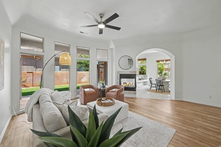 Living space featuring wood-finish flooring, a contemporary fireplace with tile surround, and an arched doorway