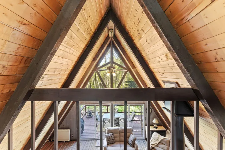 Vaulted wood-paneled ceilings with exposed dark beams define this open interior