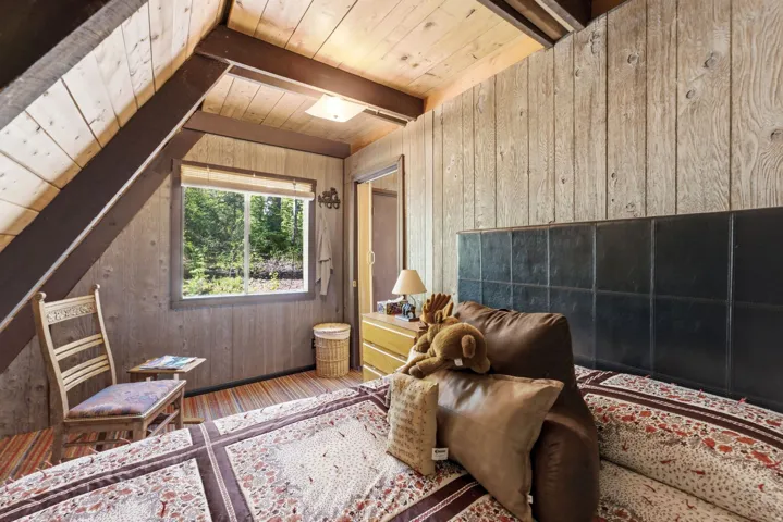 Room featuring wood-planked walls and ceilings, exposed timber beams, and wood-finish flooring