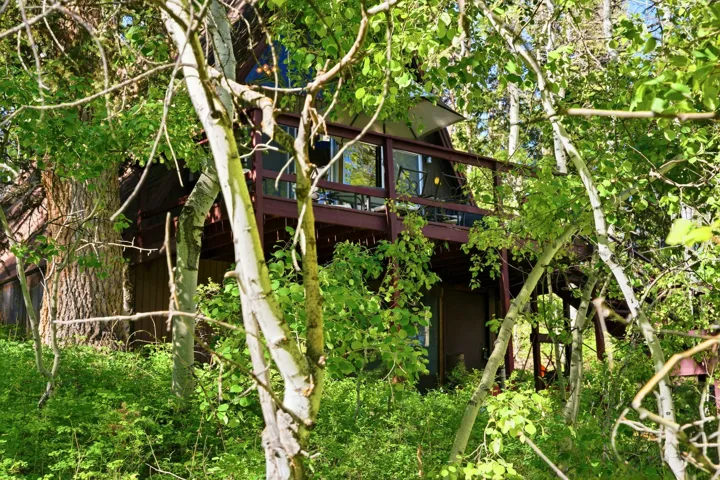 A-frame style residence featuring a dark wood exterior and a covered balcony