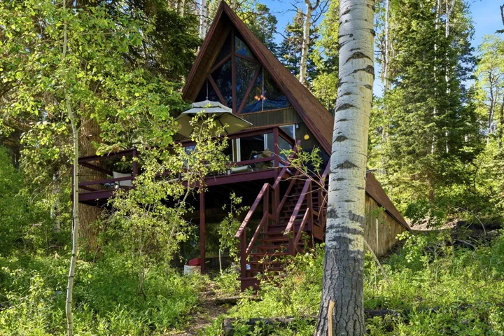 A-frame structure featuring a raised deck, extensive decking, and large front windows