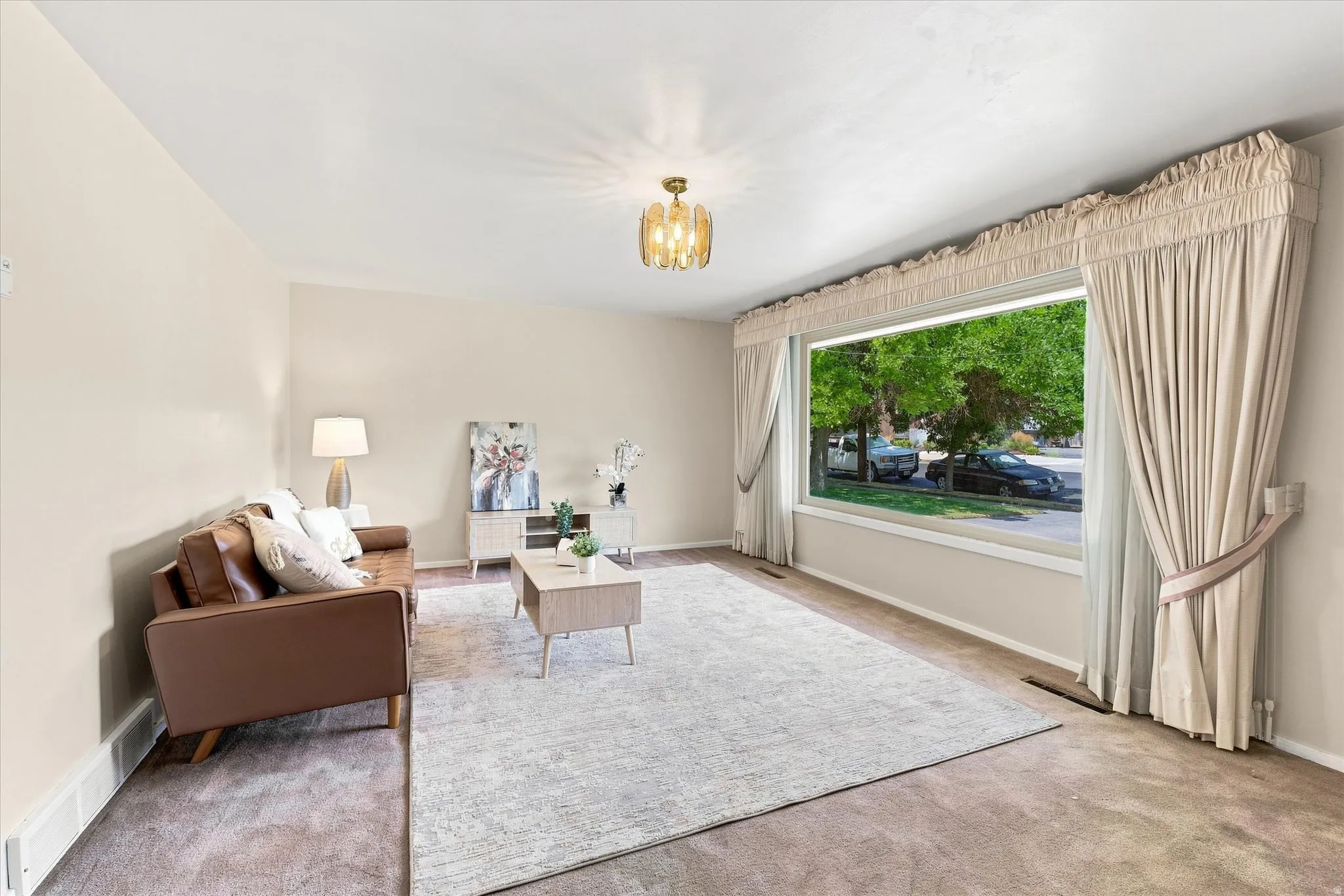 Expansive living area with neutral wall tones and a large picture window