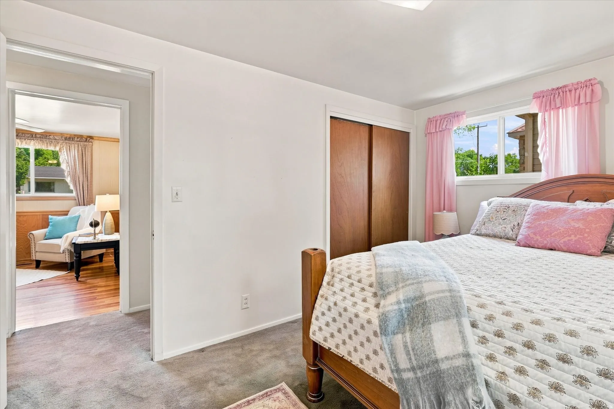 Carpeted bedroom with a built-in closet featuring wood-finish sliding doors
