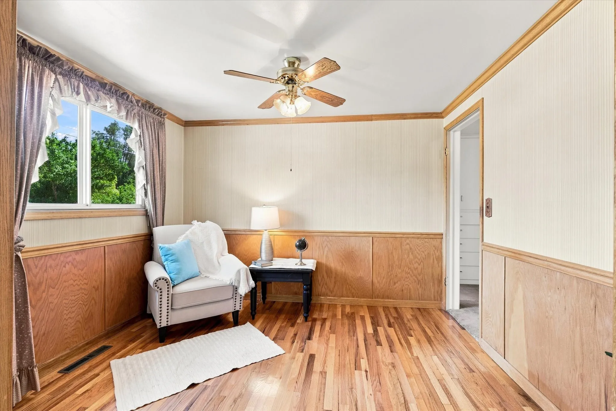 Spacious room featuring wood-finish flooring and wainscoting
