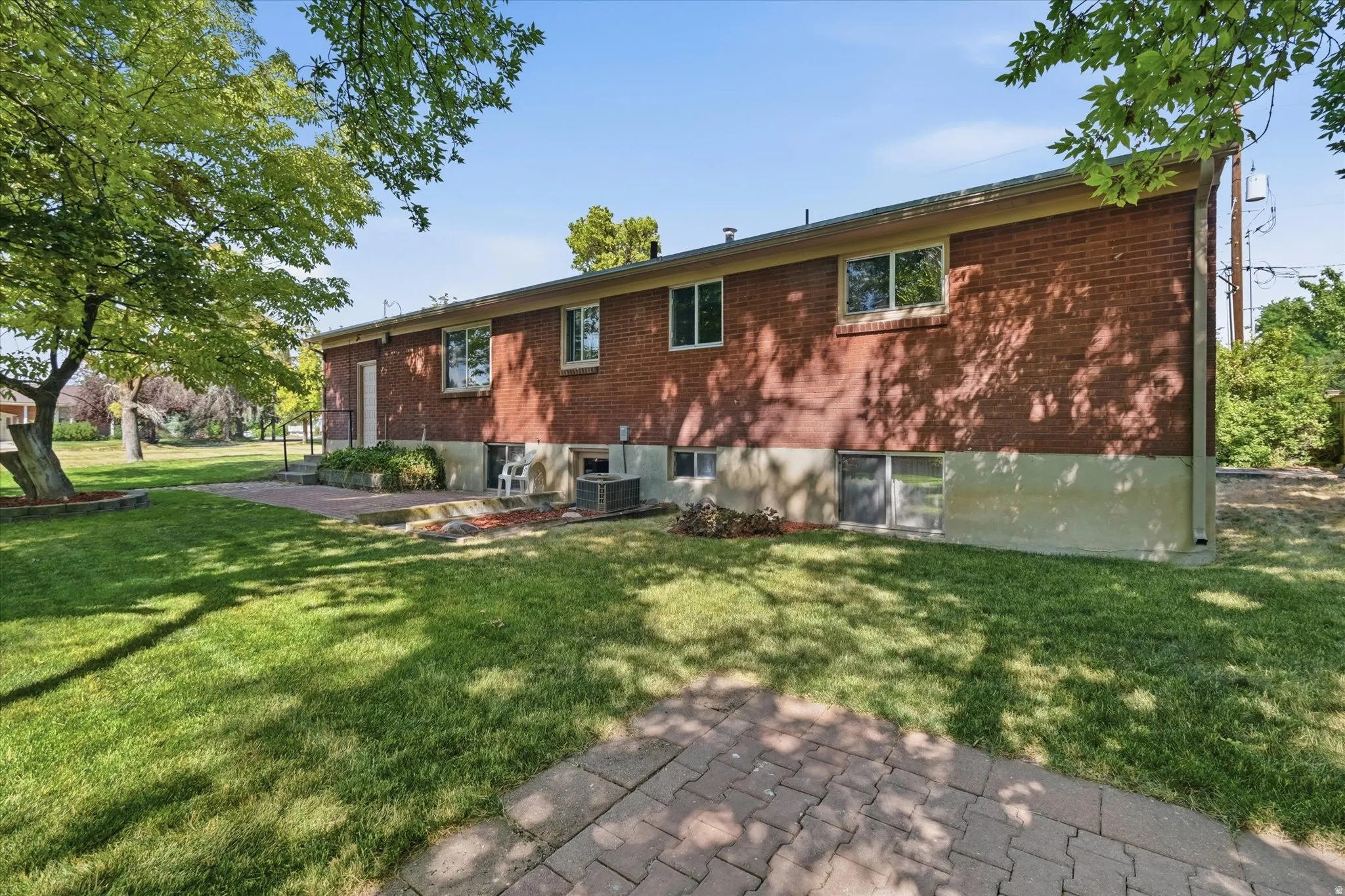 Brick exterior featuring multiple windows and a lower-level foundation