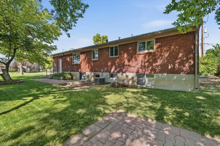 Brick exterior featuring multiple windows and a lower-level foundation