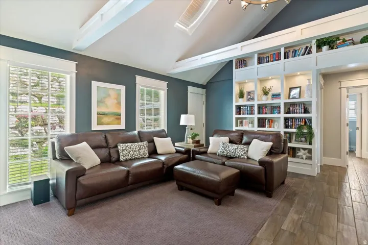 Sophisticated living room showcasing a brown leather sectional with coordinating accent pillows, anchored by a matching ottoman