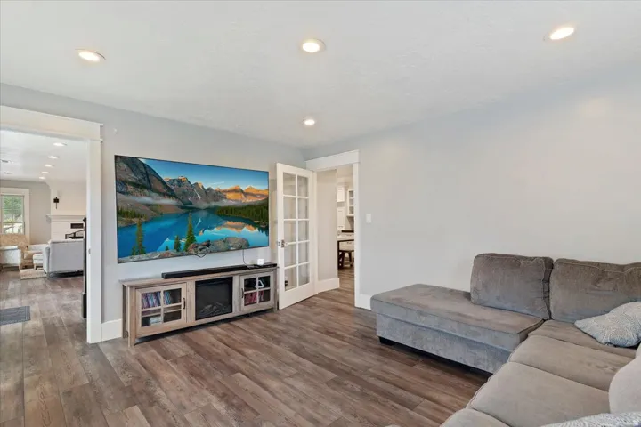 Spacious living area featuring wood-finish flooring, recessed lighting, and light gray wall tones