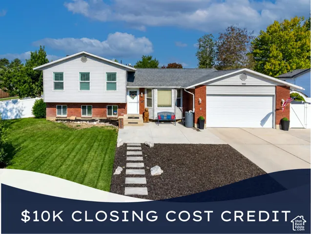 Split-level residence featuring a brick and siding exterior, an attached garage, and a concrete driveway