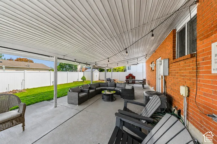 Expansive covered patio featuring a corrugated metal ceiling, concrete flooring, and integrated lighting