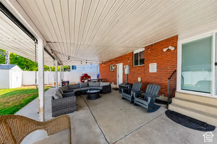 Expansive covered patio featuring a concrete slab, white paneling ceiling, and string lighting