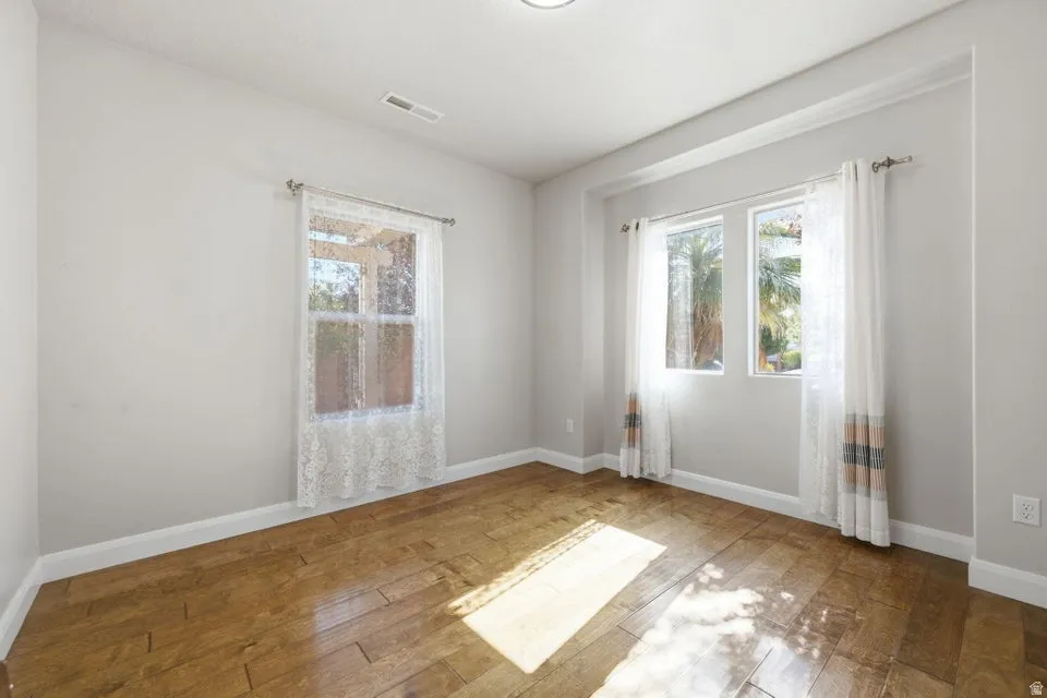 Room featuring wood-finish flooring, recessed lighting, and multiple windows