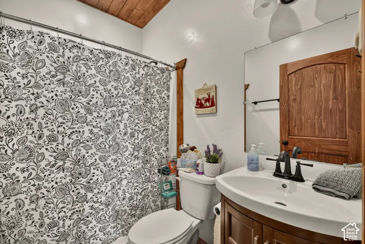 Bright bathroom featuring a curved vanity with black hardware and faucet, white ceramic sink, and ample counter space