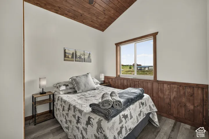 Vaulted wood-paneled ceiling with a matching accent wall below a window