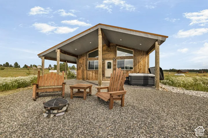 Modern cabin-style retreat featuring warm wood siding and substantial timber posts, anchored by a covered front porch with Adirondack seating