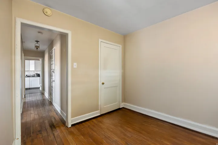 Hardwood flooring extends throughout the room and into the hallway