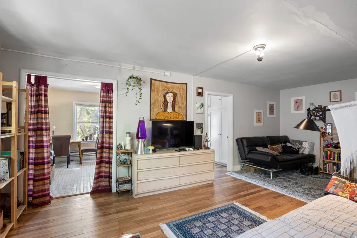 Hardwood flooring throughout a spacious room with light gray walls