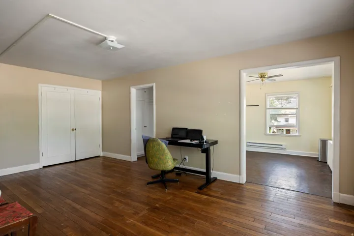 Hardwood flooring extends throughout this room, featuring a double-door closet and a recessed doorway leading to an additional space