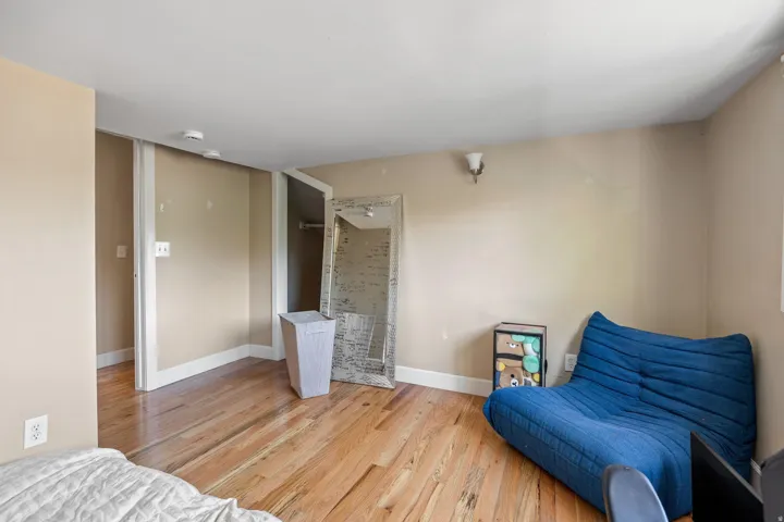 Wood-finish flooring throughout, featuring neutral wall tones and a white trim baseboard