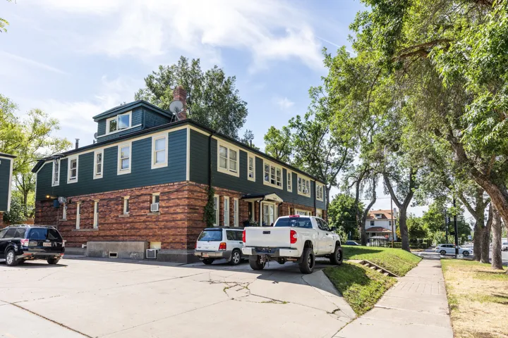 Multi-story building featuring a brick facade on the lower level and teal siding on the upper levels