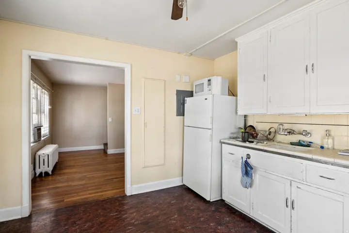 Kitchen featuring white cabinetry, a built-in sink, and a refrigerator