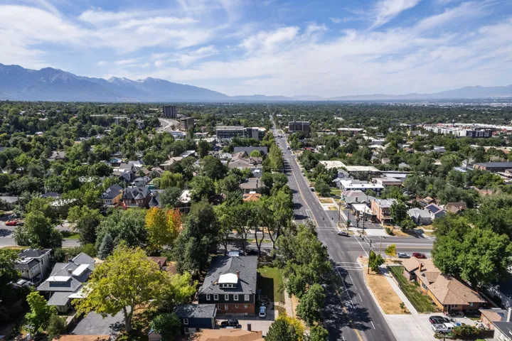 Expansive aerial perspective showcasing a tree-lined residential area with a prominent arterial road