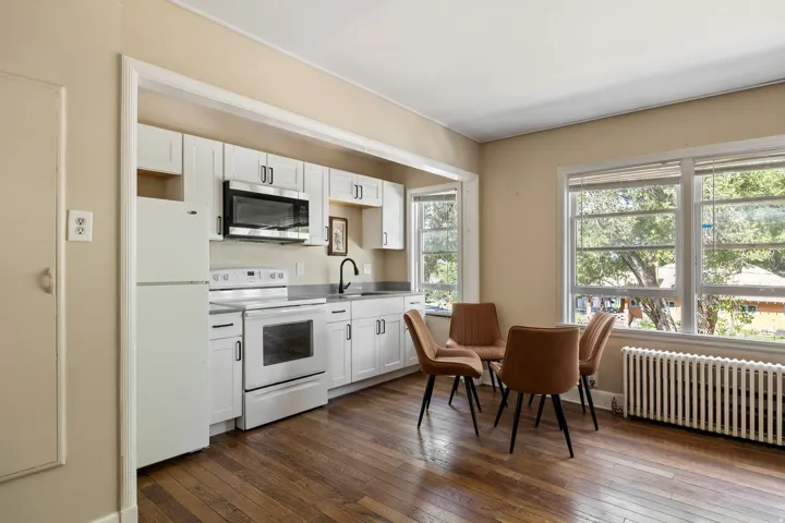 Kitchen area with wood-finish flooring and multiple windows