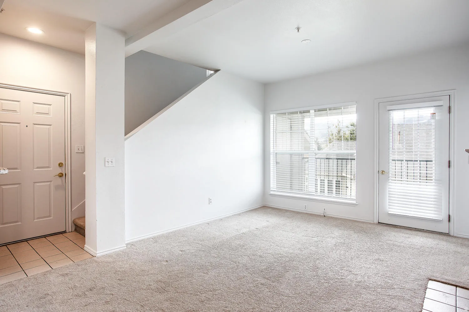 Living area featuring light beige carpeting and white walls