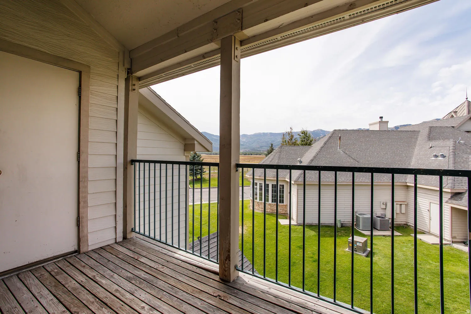 Spacious composite deck featuring composite wood-finish flooring, sturdy support columns, and black aluminum railing with vertical balusters