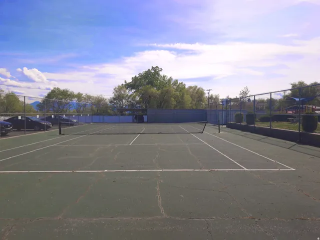 Full-size tennis court featuring a net and white court lines