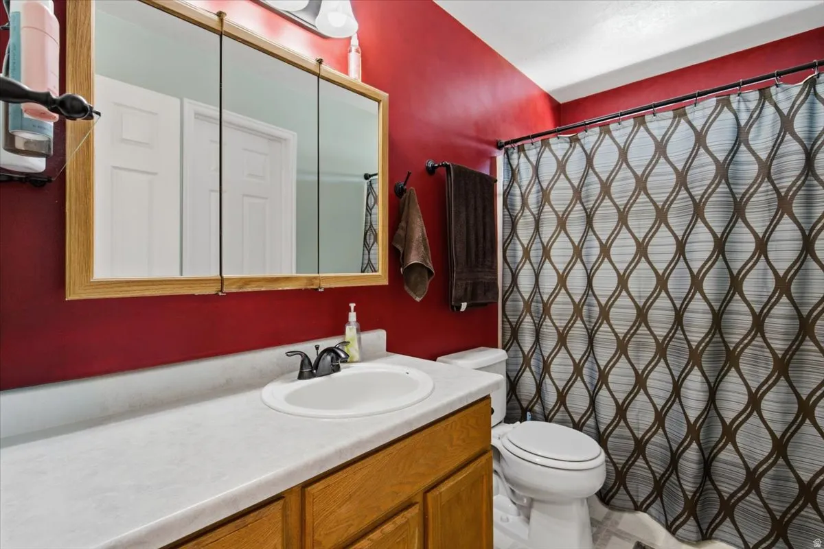Bathroom vanity with a light wood-finish cabinet, white countertop, and single basin sink