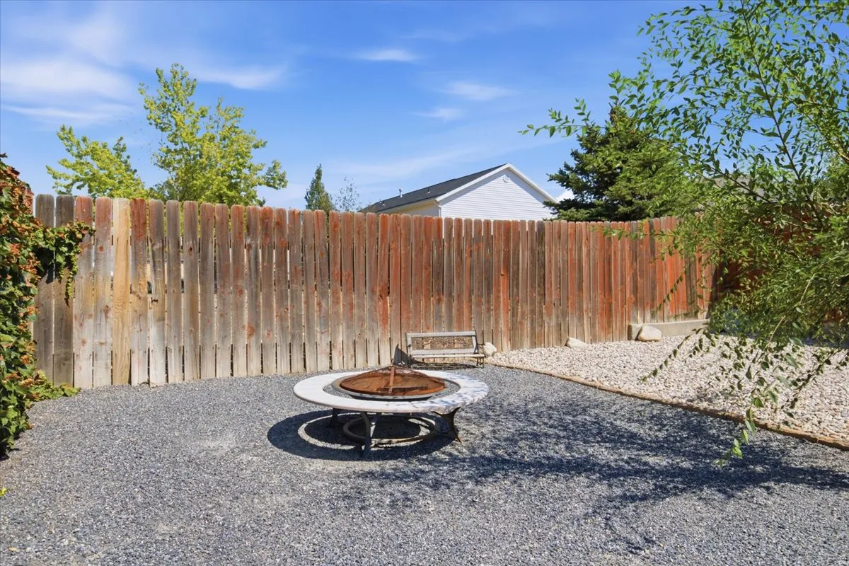 Outdoor fire pit area featuring a stone-look surround and metal fire bowl