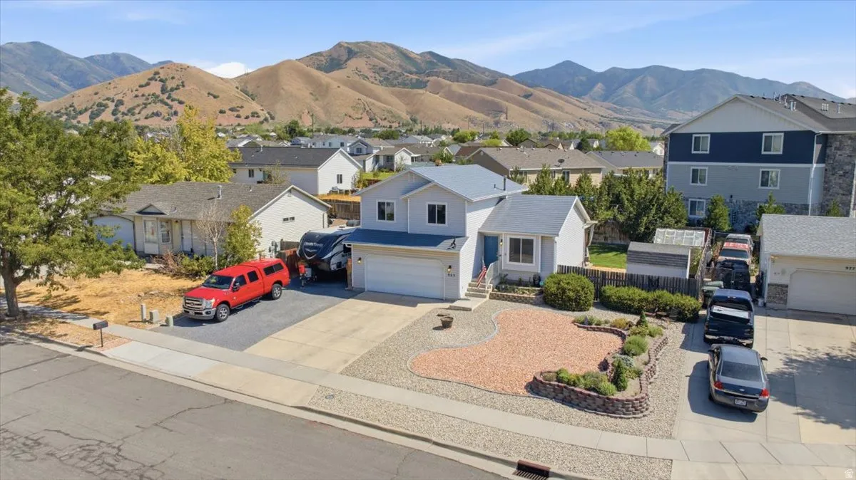 Charming single-story residence featuring a white exterior with blue-grey accents, situated on a landscaped corner lot