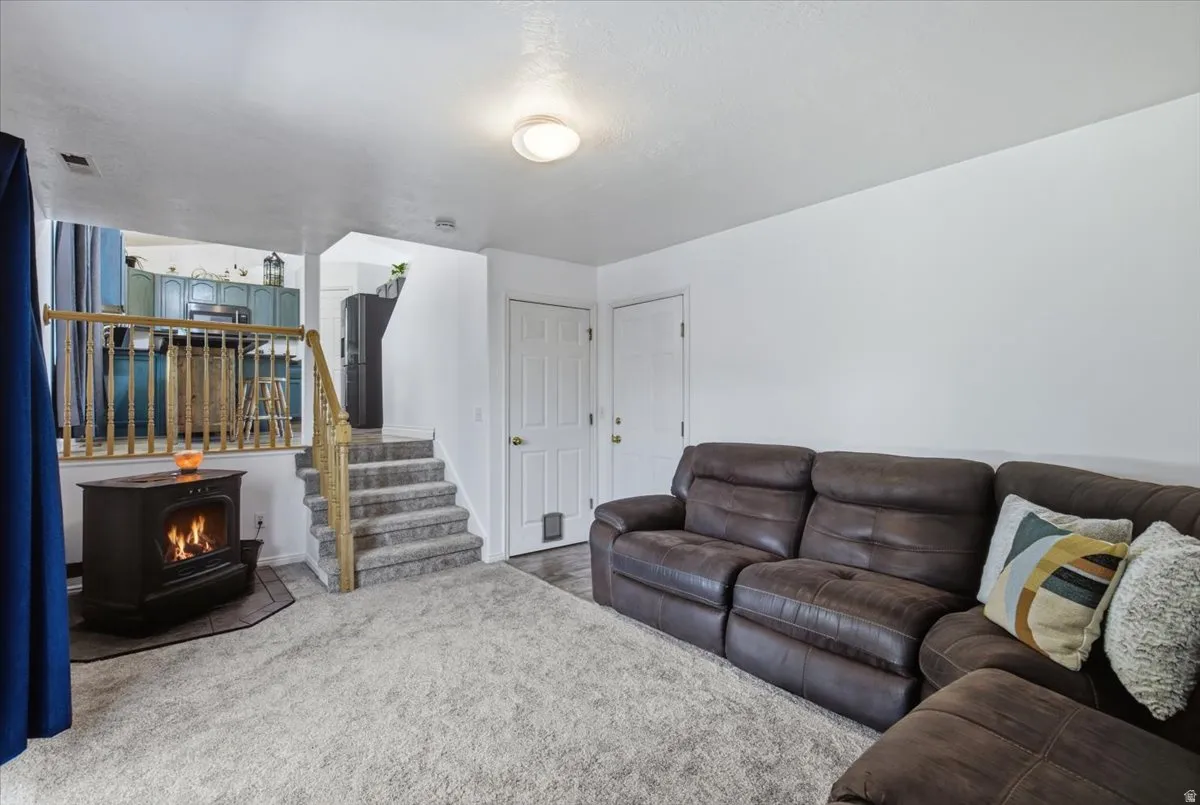 Versatile basement recreation space featuring plush leather sectional seating, neutral carpet flooring, and recessed ceiling lighting
