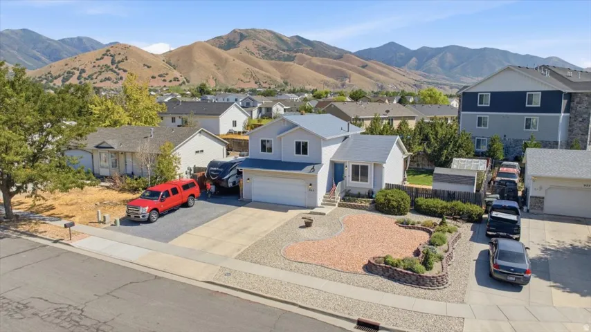 Charming single-story residence featuring a white exterior with blue-grey accents, situated on a landscaped corner lot