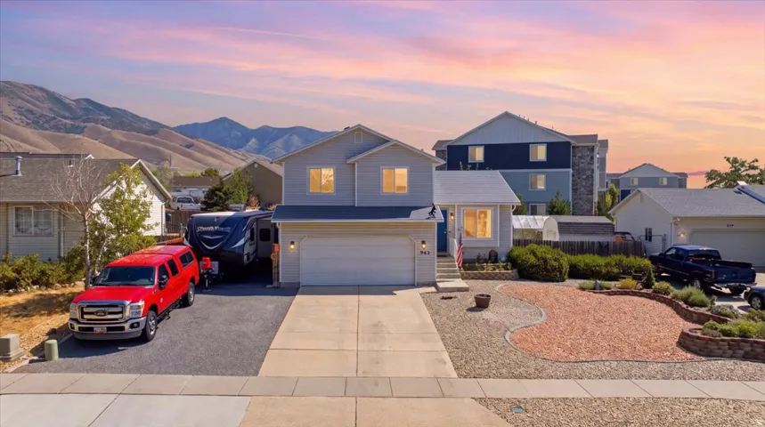 Two-story residence featuring light gray siding, a two-car garage, and a concrete driveway