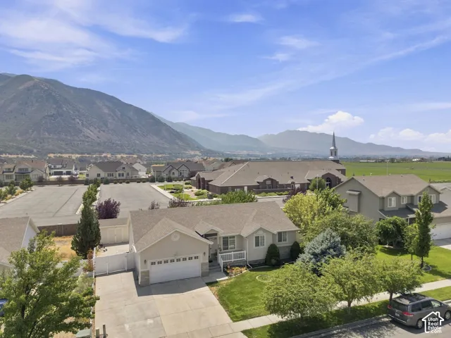 Stunning single-story residence featuring a two-car garage, mature landscaping with established trees, and expansive manicured lawn