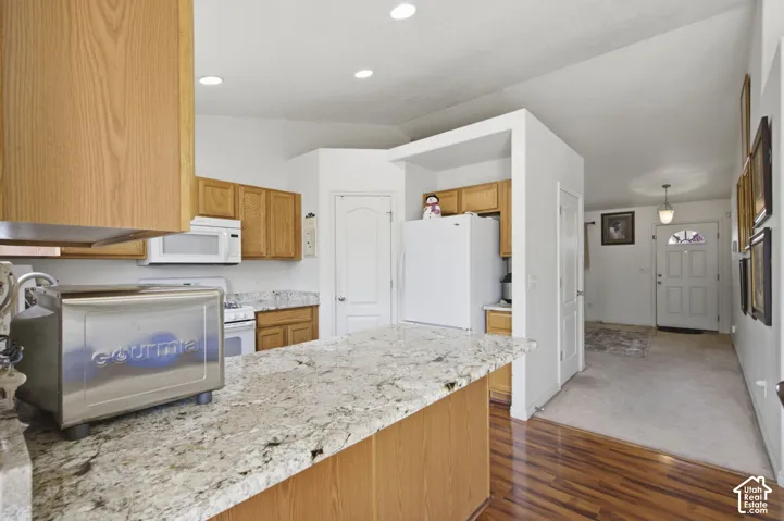 Spacious kitchen featuring wood cabinetry, granite countertops, recessed lighting, and bamboo flooring throughout