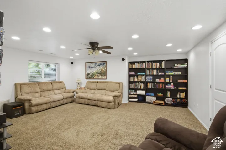 Spacious room featuring neutral carpeting, a ceiling fan with integrated lighting, and recessed overhead lighting