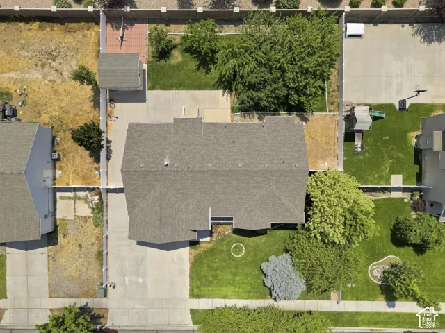 Aerial view showcasing a well-proportioned residence featuring a charcoal-gray asphalt shingle roof, concrete driveway, and landscaped grounds