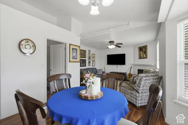 Open dining area featuring a round wood table with seating for four, bamboo flooring, and ceiling fan with integrated lighting