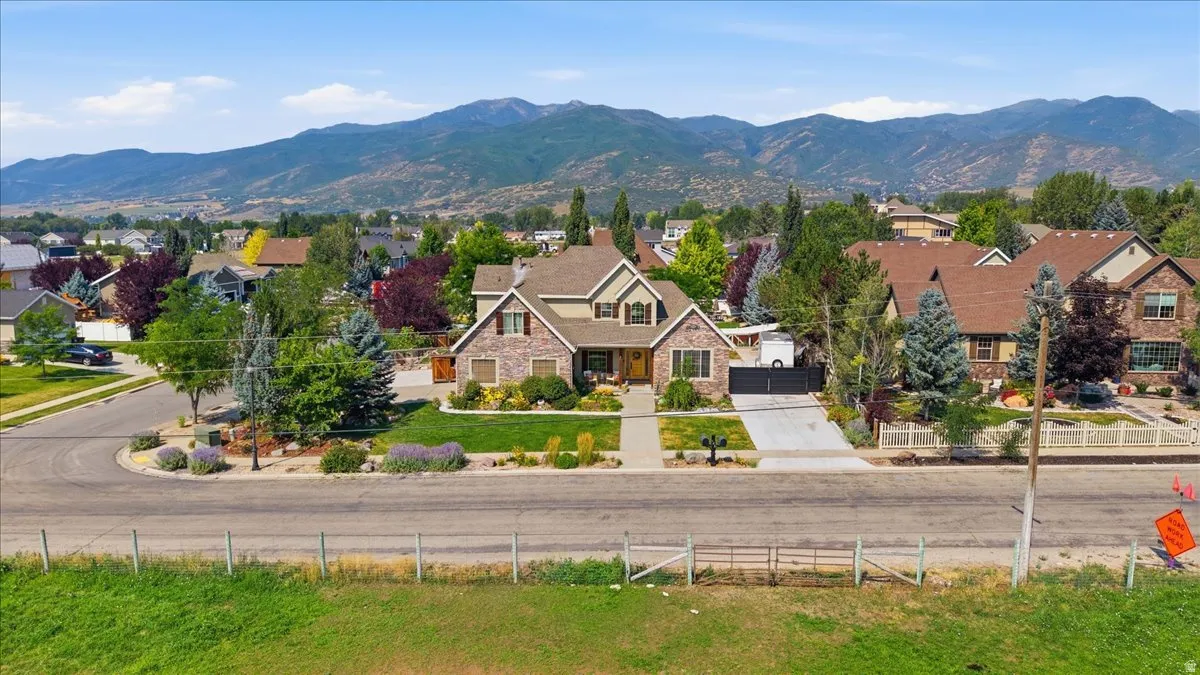 Elegant two-story residence featuring a composite or stone exterior with multiple peaked rooflines and architectural detailing