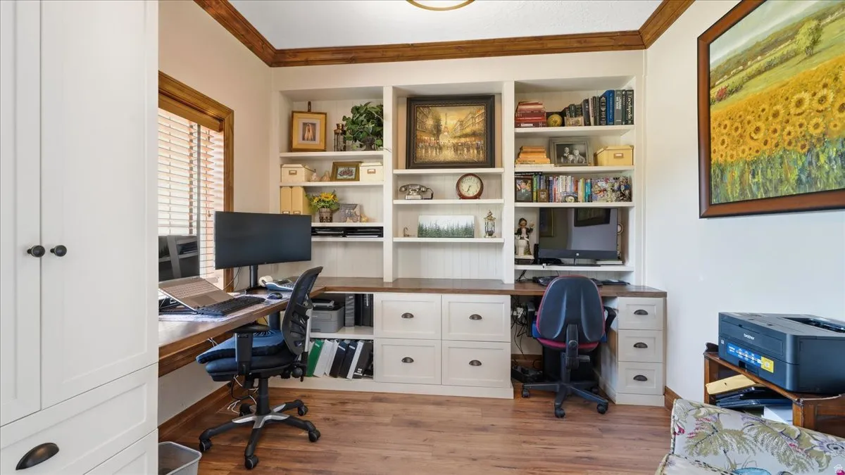 Dedicated home office featuring built-in cabinetry with open shelving, dual workstations with ample counter space, and file storage