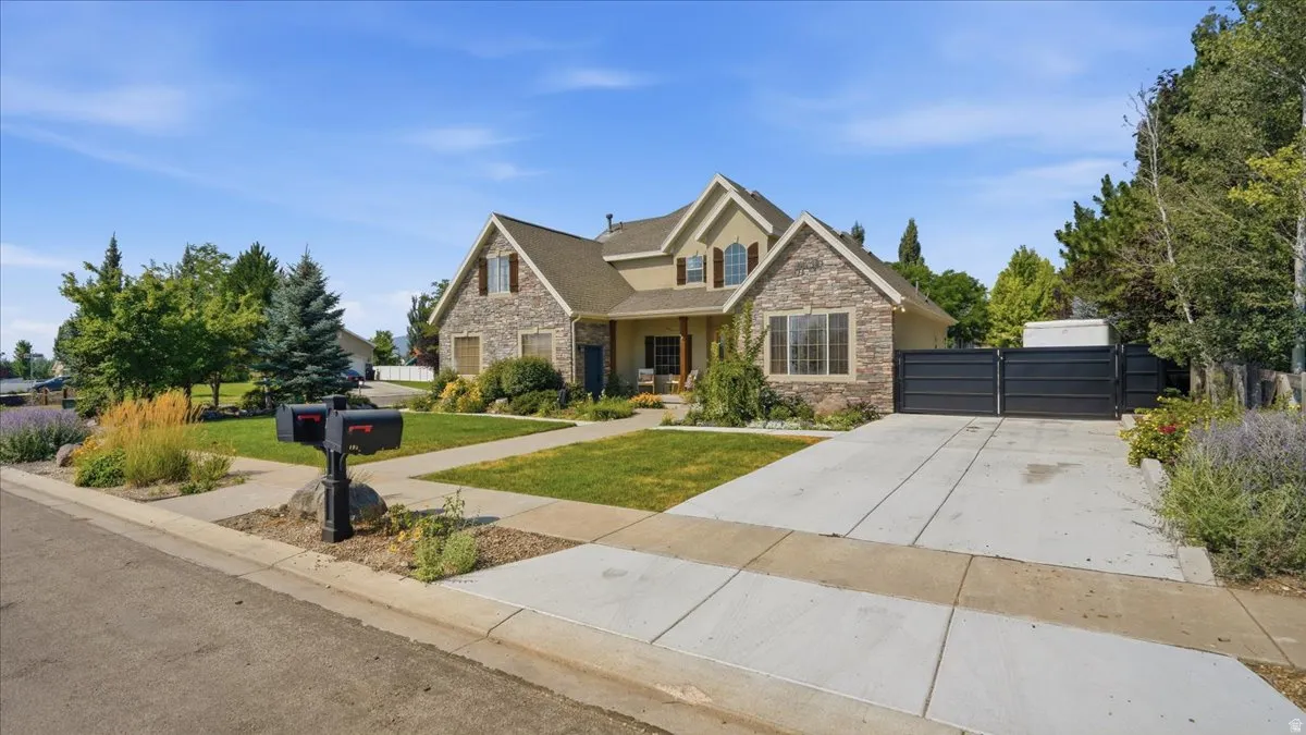 Elegant brick and stone two-story residence featuring a gabled roofline, arched entryway, and multi-pane windows