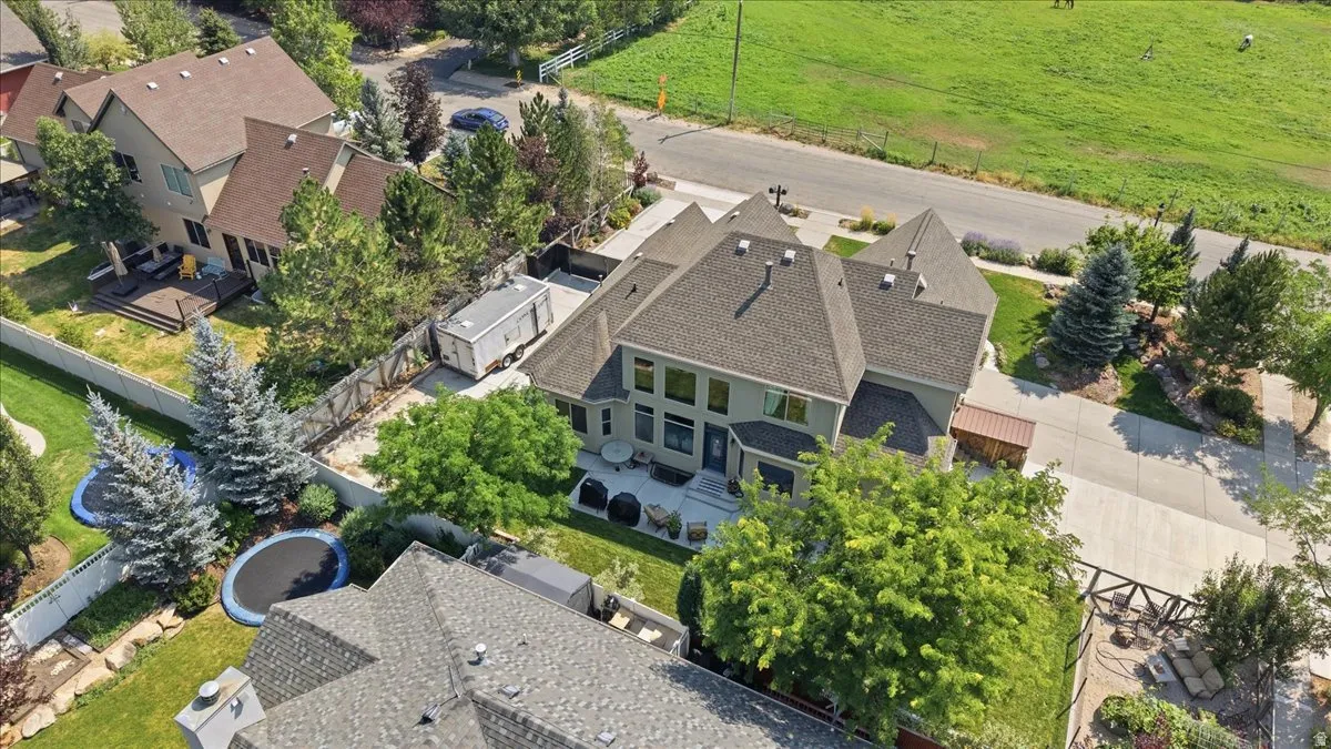 Multi-level property with a neutral-toned exterior, gabled roofline, and extensive paved driveway