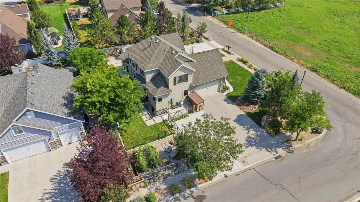 Elegant two-story residence showcasing a manicured landscape with mature trees, circular driveway, and thoughtfully designed hardscaping