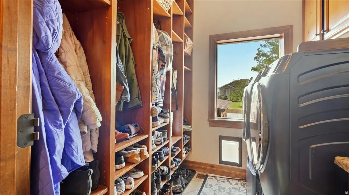 Spacious walk-in closet featuring custom wood-finish cabinetry with multiple shelving units, hanging rods, and abundant storage throughout